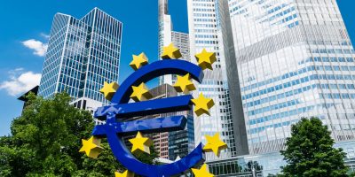 Euro sign and skyscraper at the financial district of Frankfurt am Main, Hesse, Germany, July 2017