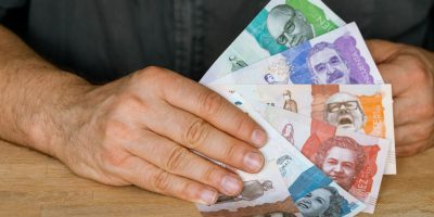 Colombia currency, a man holds a fan of money in his hand, Business and financial concept