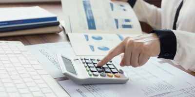 business women using a calculator to calculate the numbers for audit and evaluation performance. finance accounting concept